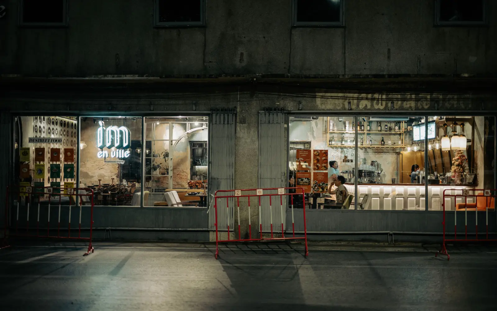 Cafe frontage at night with warm interior light and a neon sign