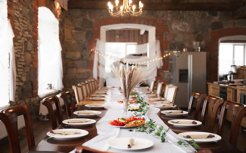 A long table set for a private event in a stone-walled dining room